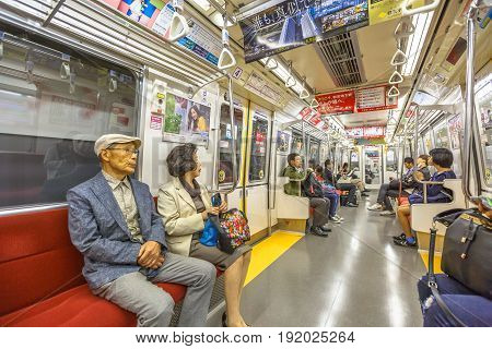 Tokyo, Japan - April 17, 2017: asian people subway wagon inside in Toei Oedo Line, a subway line in Tokyo. On maps and signboards, the line is shown in magenta and the stations carry the letter E.