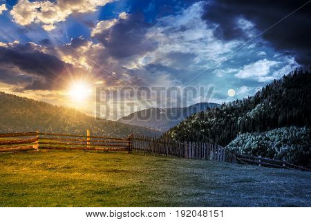 Fence Through The Grassy Meadow In Mountains Time Change Concept