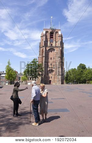 Leeuwarden Netherlands 11 june 2017: young black man talks to older couple near old lopsided tower oldehove in the center of ancient city Leeuwarden in the netherlands