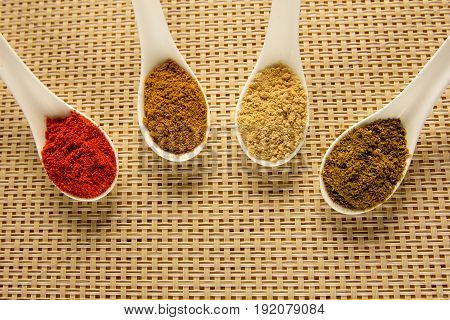 Spices in spoons on the table. Seasoning in powder.