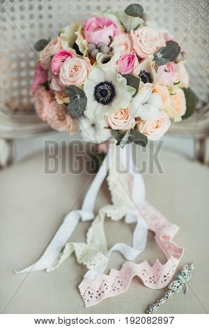 Wedding accessories: boutonniere and bride's bouquet on the chair