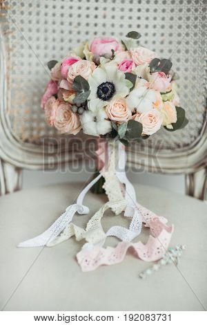 Wedding accessories: boutonniere and bride's bouquet on the chair