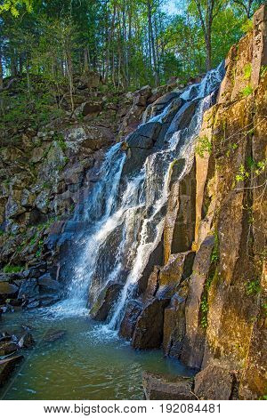 a beautiful waterfall in the forest. Wildlife, waterfalls in a deserted forest. taiga. strong and tall waterfall in forest