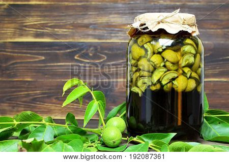 Preparing liqueur made of green walnuts on wooden background