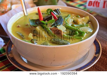 green thai curry and rice in a bowl with vedgetables, chicken chilli.