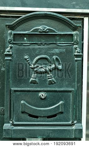Black vintage iron mailbox. Vertical image. Letterbox.