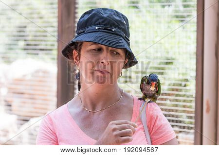 Young woman feeds parrots at the Australian Zoo Gan Guru in Kibbutz Nir David in Israel