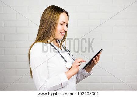 Smiling doctor using a tablet computer in a hospital