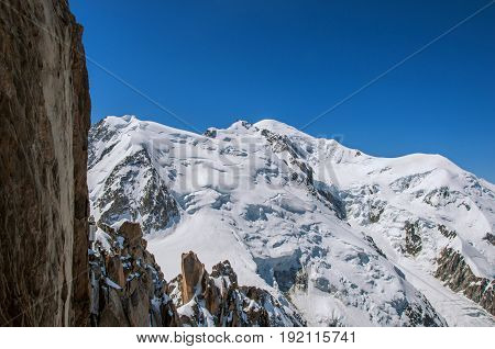 View of the Mont Blanc and rocks from the Aiguille du Midi, in French Alps Chamonix Mont Blanc, alpine mountains landscape, clear blue sky in warm sunny summer day