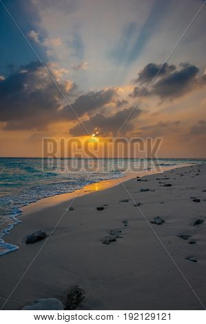 Sunset in the Maldives. Beautiful colorful sunset over the ocean in the Maldives seen from the beach.Amazing sunset and beach in Maldives. Calm water