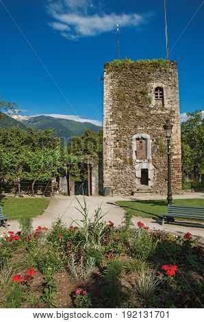 Conflans, France - June 29, 2016. Square, stone building and flowery garden in city center of Conflans, a medieval hamlet in Haute-Savoie department, Auvergne-Rhône-Alpes region, south-eastern France