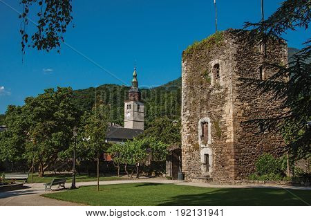 Conflans, France - June 29, 2016. Square, belfry, stone building and garden in city center of Conflans, a medieval hamlet in Haute-Savoie department, Auvergne-Rhône-Alpes region, south-eastern France