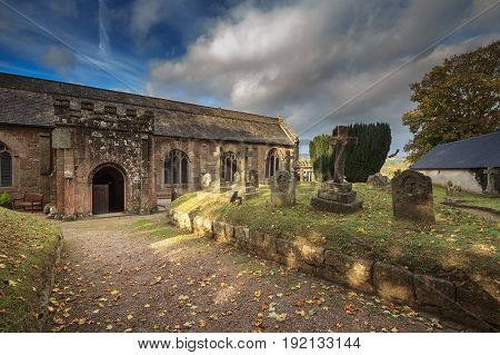 Courtyard of the Anglican Church. You can see old graves. Autumn evening. Clouds in the blue sky. Chagford. Devon. England