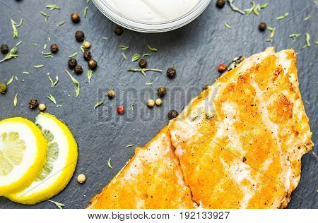 Grilled salmon steak with fresh lemon top view.