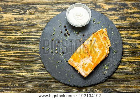 Grilled salmon steak with fresh lemon top view.