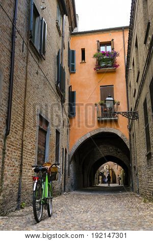 Bicycle parked near the wall of an ancient house in an Old Town of Ferrara, Italy