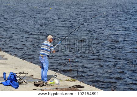 An unidentified person fishing.Modern residential area Obolon.June 21 ,2017 in Kiev, Ukraine