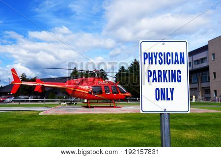 KALISPELL, MONTANA, USA - June 19, 2017: Physician parking only sign in front of an air ambulance at Kalispell Regional Medical Center