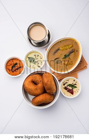 south indian food called vada sambar or sambar vada or wada, served with coconut, green and red chutney over fresg banana leaf, selective focus