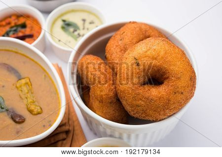 south indian food called vada sambar or sambar vada or wada, served with coconut, green and red chutney over fresg banana leaf, selective focus