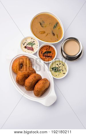 south indian food called vada sambar or sambar vada or wada, served with coconut, green and red chutney over fresg banana leaf, selective focus