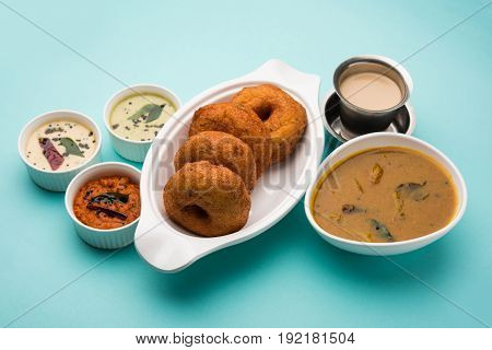 south indian food called vada sambar or sambar vada or wada, served with coconut, green and red chutney over fresg banana leaf, selective focus