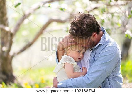 Father Holding And Comforting Sad Baby Daughter