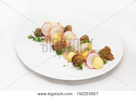 Sugudai from omul fish from Baikal with potato balls biscuits and radish on white background