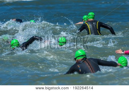 Kijkduin The Hague the Netherlands - 17 June 2017: Kijkduin cross triathlon athletes running into the sea for swim leg