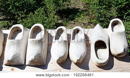 Dutch wooden shoes on a wood background. Pair of traditional clogs made of wood. Klompen traditional Dutch shoes for everyday use top view