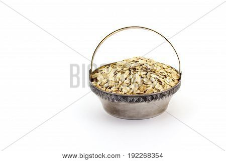 A Silver Bowl Of Uncooked Rolled Oats Isolated On White Background