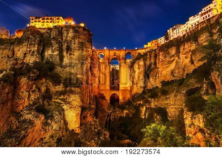 The popular historic landmark of spectacular Puente Nuevo, New Bridge, illuminated at night, over Guadalevin River in town of Ronda, Andalusia, Spain.