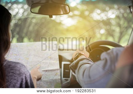 Asian man and woman using map on roadtrip and Happy young couple with a map in the car. Blurred and Soft focus