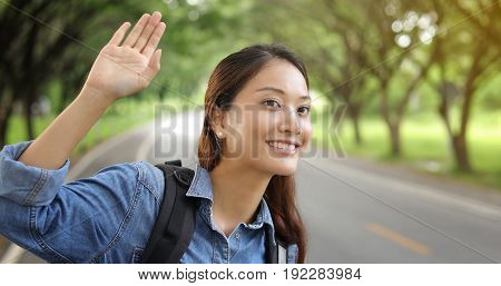 women asian with bright backpack and Freedom traveler woman standing with raised arms and enjoying a beautiful nature