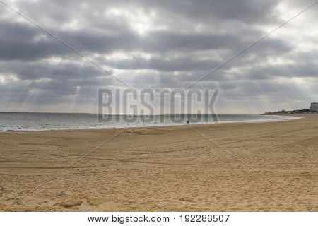 cloudy sky with sunbeams on a beach