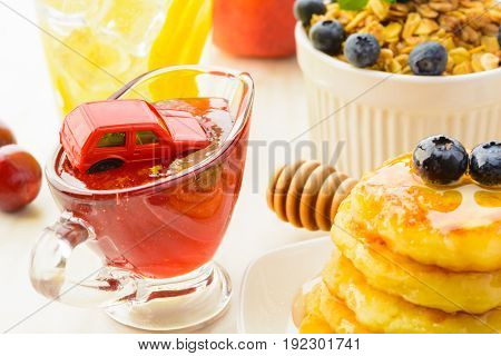 Toy red car in jam like morning traffic concept in rush hour after healthy breakfast closeup view