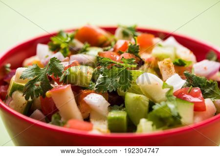 Indian Green Salad also known as Kachumber is a colourful salad dish in Indian cuisine consisting of fresh chopped tomatoes, cucumbers, onions, and sometimes, chili peppers. selective focus