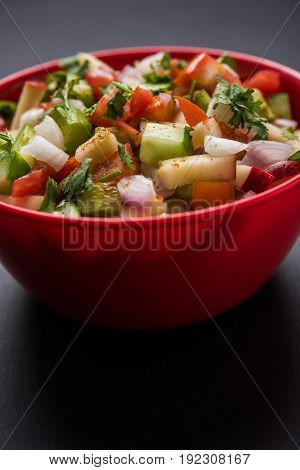 Indian Green Salad also known as Kachumber is a colourful salad dish in Indian cuisine consisting of fresh chopped tomatoes, cucumbers, onions, and sometimes, chili peppers. selective focus