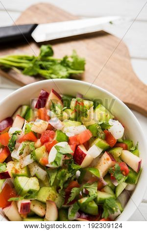Indian Green Salad also known as Kachumber is a colourful salad dish in Indian cuisine consisting of fresh chopped tomatoes, cucumbers, onions, and sometimes, chili peppers. selective focus