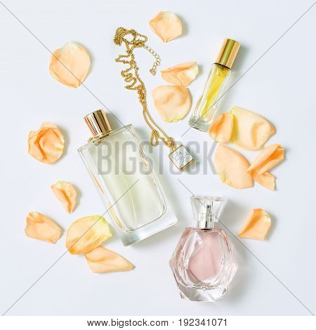 Perfume bottles with flowers petals on white background. Perfumery, cosmetics, jewelry and fragrance collection. Stylized feminine flatlay. Women accessories top view