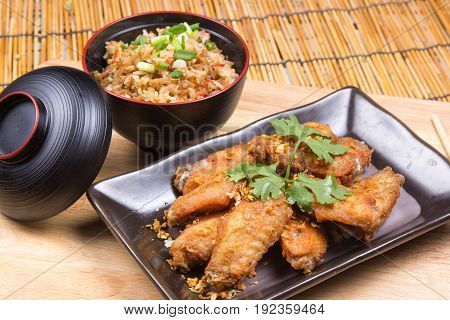 Fried chicken wings served with fry rice / cooking fried chicken wings concept