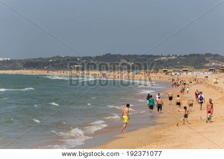 ALVOR, PORTUGAL - APRIL 23, 2017: People at the famous beach of Praia do Alvor, Algarve region, Portugal