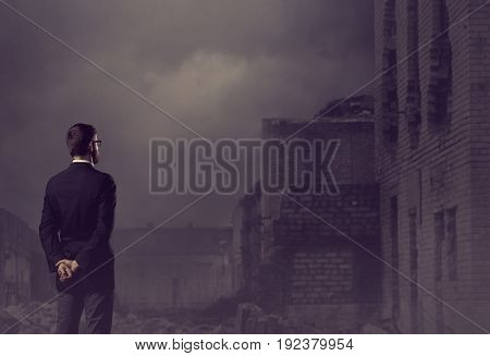 Businessman standing over apocalyptic background. Crisis, default, setback concept.