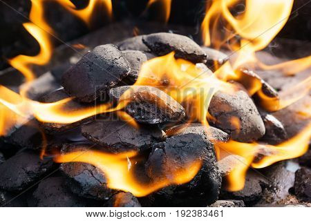 embers and blazing fire on a bbq grill.