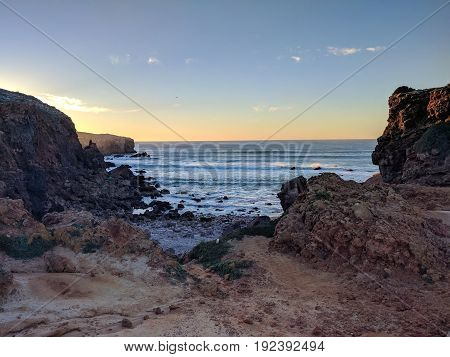 Rocky beach and waves meet the ocean sunset