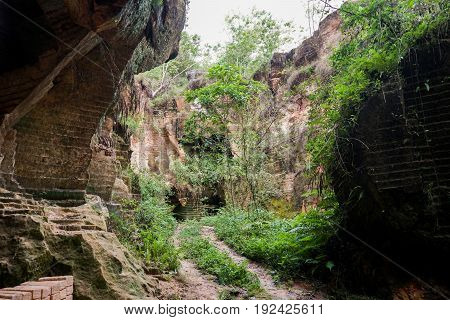 The exploitation of limestone hills canyon forming a unique architectural in Arosbaya Hill Madura Island, Indonesia