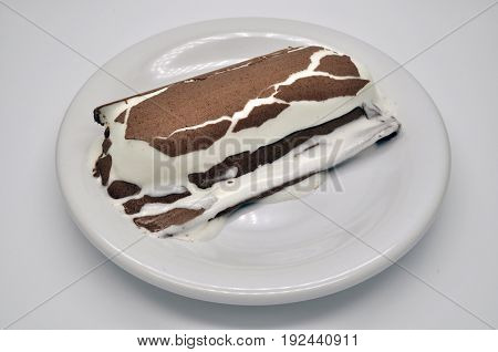 one ice-cream Lakomka ice-cream in melted chocolate on a white plate on a saucer with napkin isolated on white background