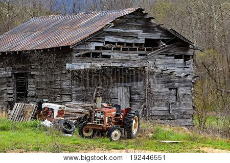 An old abandoned barn with tractors out front in North Carolina