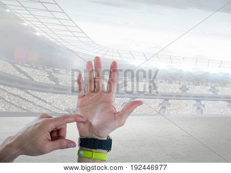 Digital composite of Hand counting with a sports stadium
