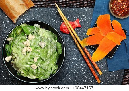 Buttery Lettuce Salad with Blue Cheese Crumbles, dried mango and bread at table.